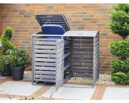 Doppel-Mülltonnenbox aus Holz im Garten vor einer Ziegelwand