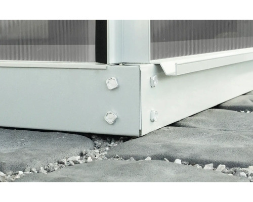 Detailansicht eines Gewächshausrahmens aus Metall mit Schrauben auf Steinboden