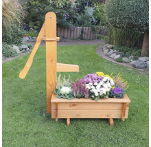Dekorative Holz-Gartenpumpe mit Blumenkasten auf Rasen