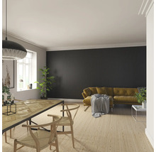 Wohnzimmer mit Esstisch, Stühlen und Sofa vor einer Wandpaneele