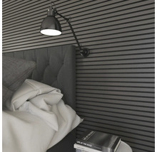 Schlafzimmer mit Bett, Nachttisch, Wandpaneelen und Wandleuchte