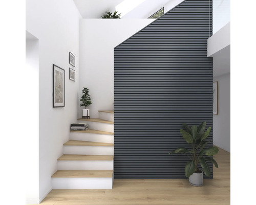 Heller Raum mit Treppe, Wandpaneelen und Zimmerpflanzen für ein freundliches Ambiente.