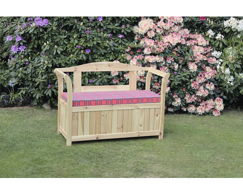 Gartenbank aus Holz mit Stauraum und kariertem Sitzkissen vor blühenden Sträuchern