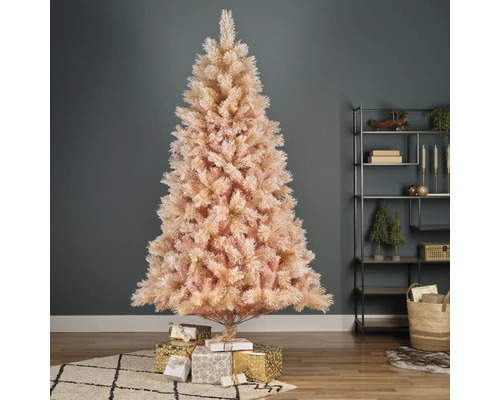 Dekorativer Weihnachtsbaum aus Kunststoff mit Geschenken im Wohnzimmer.