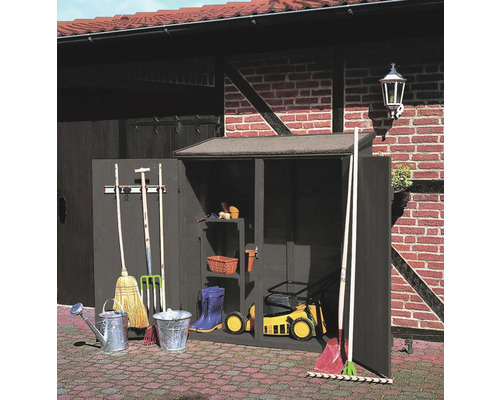 Gartenwerkzeugschrank mit Gartengeräten vor Backsteinmauer