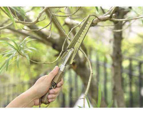 Eine Hand hält ein multifunktionales Gartenwerkzeug mit Holzgriff
