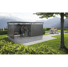 Moderne Gartenlounge mit Grillplatz und Sitzgruppe auf gepflasterter Terrasse