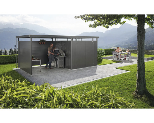 Moderne Gartenlounge mit Grillplatz und Sitzgruppe auf gepflasterter Terrasse