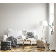 Wohnzimmer mit Sofa, Tisch, Stehlampe und Hockern auf einem Holzboden