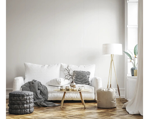 Wohnzimmer mit Sofa, Tisch, Stehlampe und Hockern auf einem Holzboden