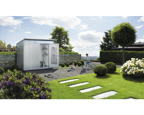 Metall Gerätehaus mit geöffneten Türen, Regalen und Werkzeugen in einem Garten mit spielenden Kindern