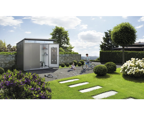 Metall Gerätehaus mit geöffneter Tür in einem Garten mit spielenden Kindern.