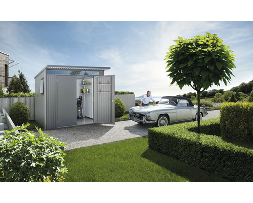 Gartenszene mit Gerätehaus, Oldtimer und Mann bei der Autopflege