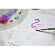 Aquarellmalerei eines Flamingos auf Papier mit Pinsel und Farbpalette