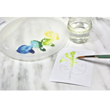 Aquarellmalerei eines Blattes mit Pinsel, Farbe, Wasser und Palette