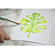 Aquarellmalerei eines Monstera Blattes mit Pinsel auf Papier
