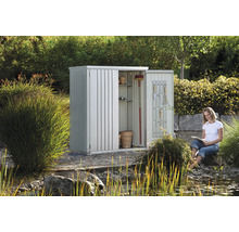Metall Gartenhaus mit Regalen und Werkzeugen im Garten mit lesender Frau