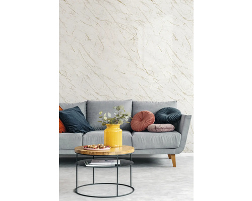 Graue Couch mit Zierkissen und Couchtisch vor einer Tapete mit Marmoroptik