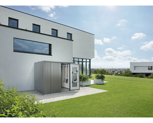 Metall Gerätehaus mit geöffneter Tür und Gartengeräten im modernen Garten