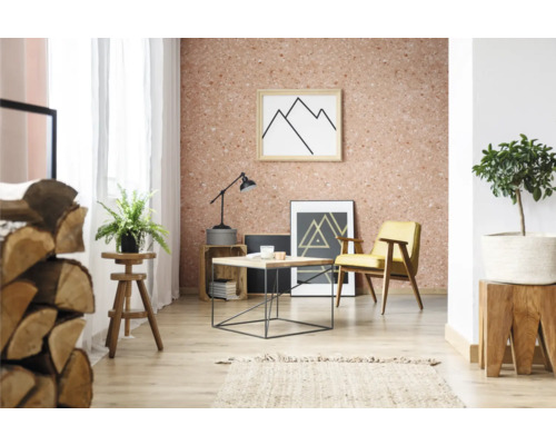 Wohnzimmer mit Korktapete, Sessel, Tisch und Dekorationen.