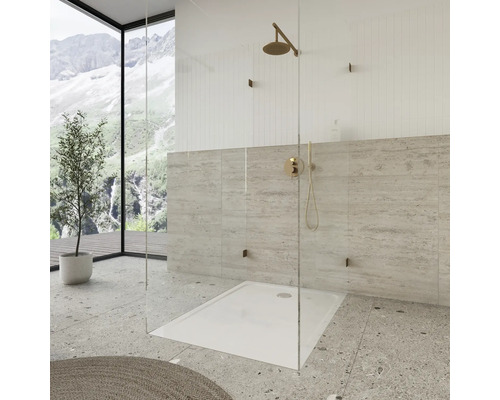 Begehbare Dusche mit Duschkopf und Armatur vor gefliester Wand