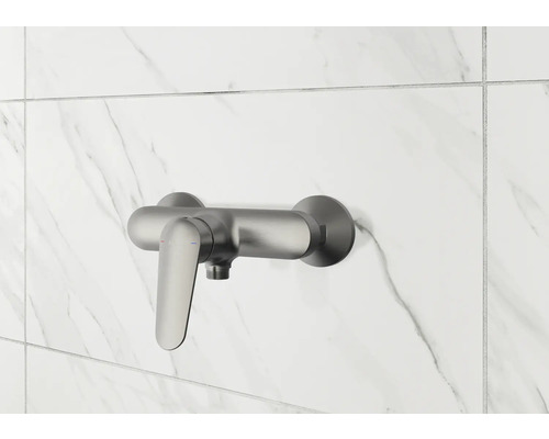 Brausearmatur aus Metall an gefliester Wand