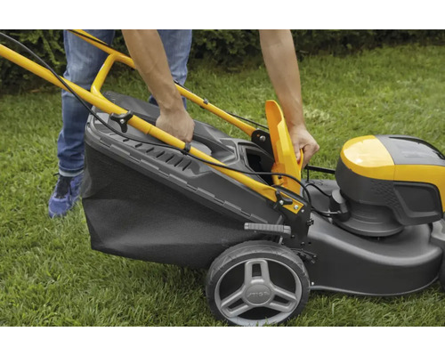 Person befestigt Fangkorb an Rasenmäher