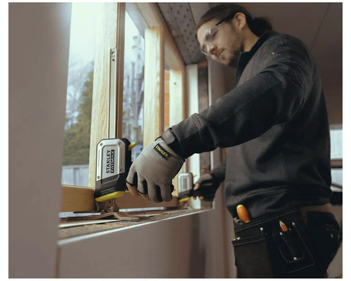 Handwerker misst Fenster mit einem Stanley Fatmax Rollbandmaß