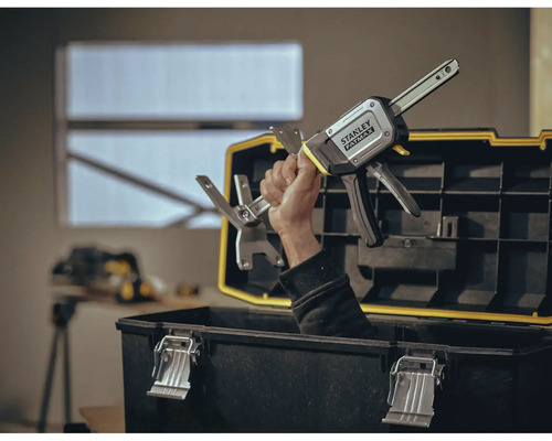 Hand hält Stanley Fatmax Einhandzwinge über Werkzeugkasten