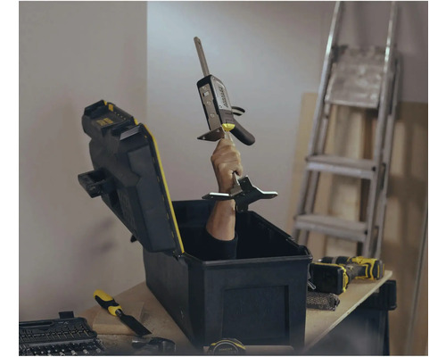 Werkzeugkasten mit Hand, die ein Messwerkzeug hält, im Hintergrund eine Leiter