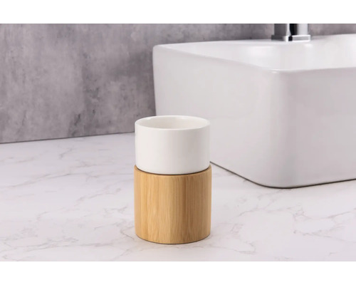 Zahnputzbecher aus Bambus und Keramik vor einem Waschbecken