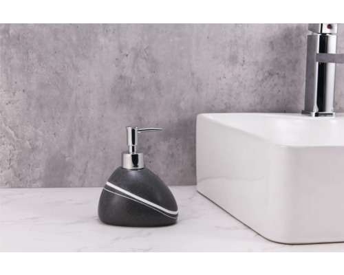 Seifenspender aus Stein mit Pumpe neben einem Waschbecken