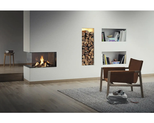 Wohnzimmer mit Kamin, Holzscheiten, Bücherregalen und Sessel auf Teppich