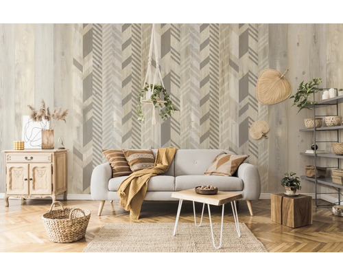 Wohnzimmer mit grauer Couch, Holztisch, Holzkiste und Wandtapete mit Pfeilmuster.