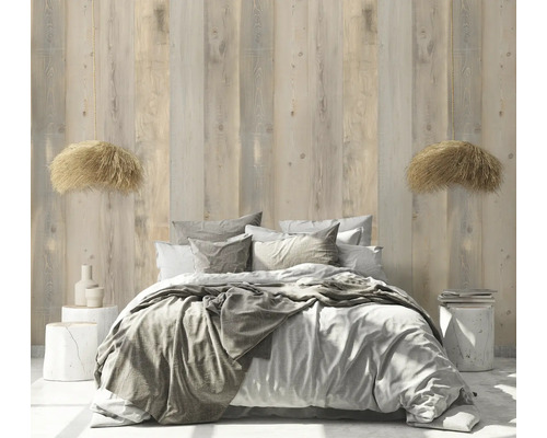 Schlafzimmer mit Bett, Kissen, Decken und Holzwandpaneelen