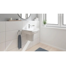 Helles Badezimmer mit Aufsatzwaschbecken, Handtuchring und Fenster für ein modernes Ambiente.