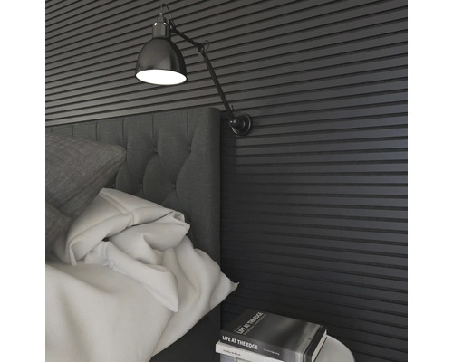 Schlafzimmer mit Bett, Lampe und Wandpaneelen