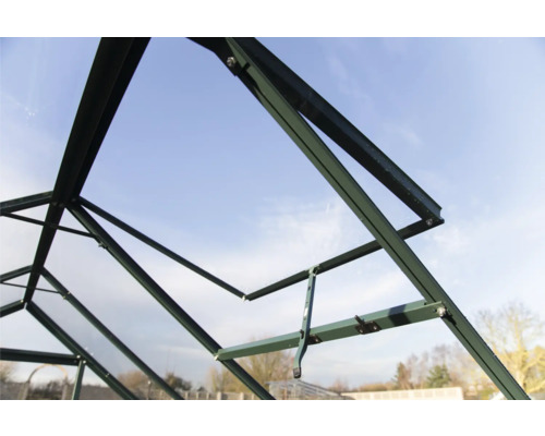 Grünes Gewächshaus im Bau, Innenansicht der Rahmenstruktur vor blauem Himmel.