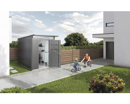 Geräteschuppen im Garten mit geöffneten Türen, in denen ein Roller und Gartengeräte zu sehen sind. Eine Frau hilft einem Kind beim Fahrradfahren.