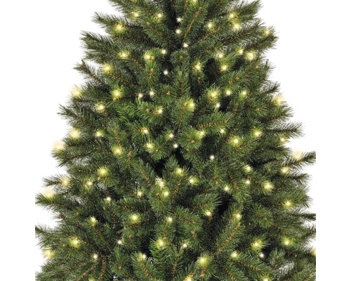 Detailaufnahme eines grünen, künstlichen Weihnachtsbaums mit Beleuchtung