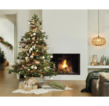Weihnachtlich eingerichtetes Wohnzimmer mit geschmücktem Weihnachtsbaum, Kamin und Geschenken