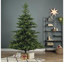 Geschmückter Weihnachtsbaum mit Geschenken in einem Wohnzimmer.