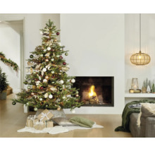 Weihnachtsbaum mit Ornamenten und Geschenken im Wohnzimmer vor Kamin