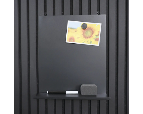 Magnettafel mit Stift, Schwamm und Foto an einer Wand montiert.