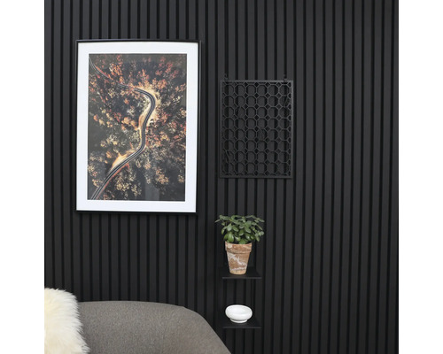 Dekorative Wandgestaltung mit geriffelten Paneelen, einem gerahmten Bild, einem Pflanzgefäß und einem kleinen Regal.