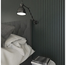 Schlafzimmer mit Bett, Nachttisch, Wandleuchte und Wandpaneelen