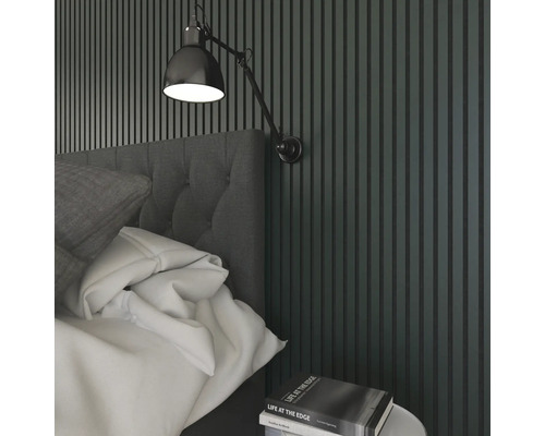 Schlafzimmer mit Bett, Nachttisch, Wandleuchte und Wandpaneelen