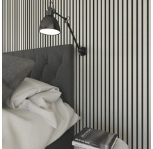 Schlafzimmer-Szene mit Bett, Nachttisch und Wandleuchte vor einer Wand mit Streifen