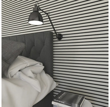 Schlafzimmer mit Bett, Lampe und Wandverkleidung in horizontalen Streifen