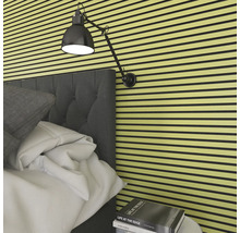 Schlafzimmer mit Akustikpaneelen an der Wand, Bett und Lampe